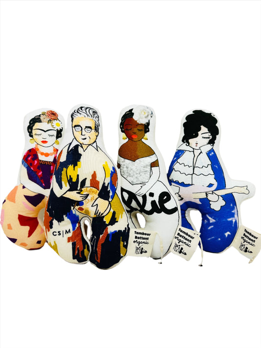Four soft fabric rattles each with an illustration of a famous artist. From left to right: Frida Kahlo, Clyfford Still, Billie Holiday, and Prince.