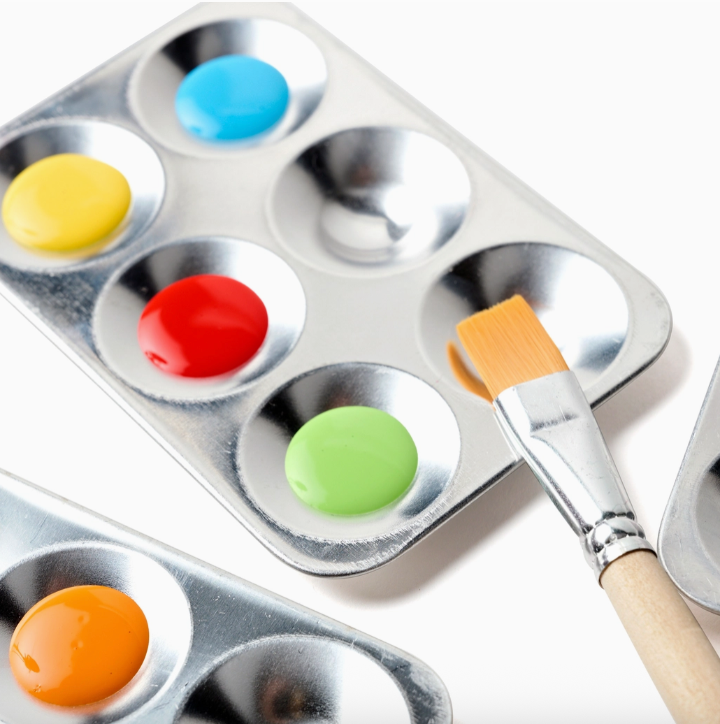 Aluminum paint palette with colorful paint samples and a brush