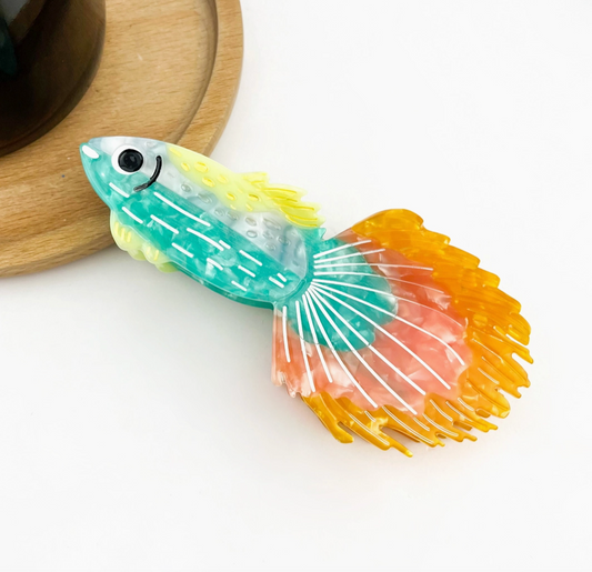 Colorful fish-shaped hair clip on a white background.