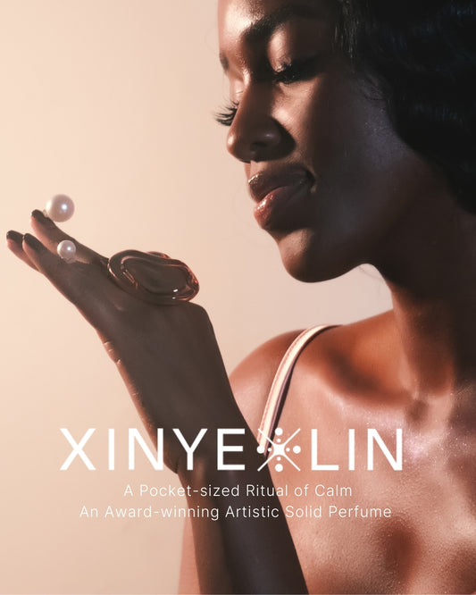 Woman holding a solid perfume with XINYE LIN branding and product description text.