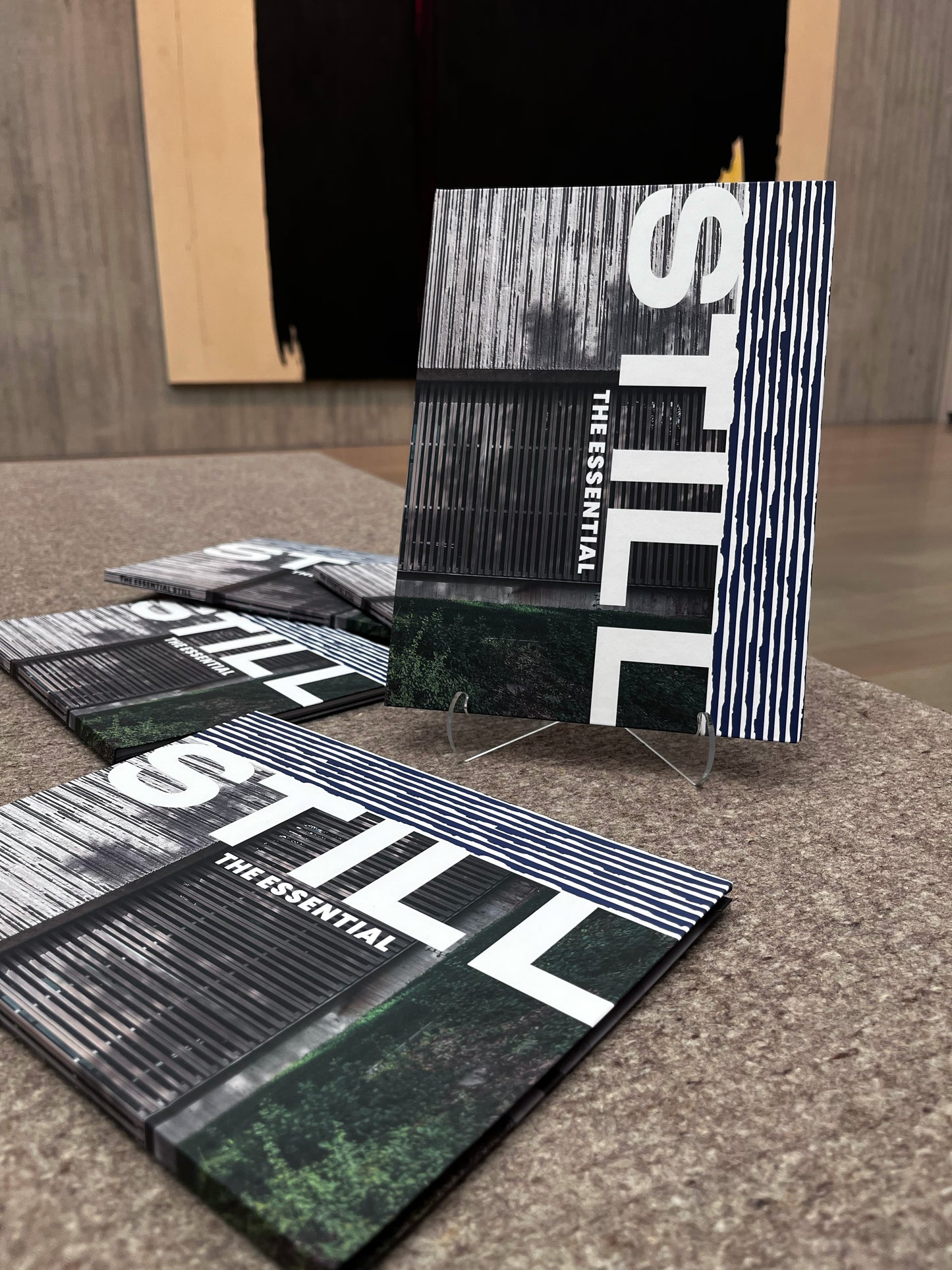 Multiple 'STILL' books displayed on a textured surface with a blurred background.