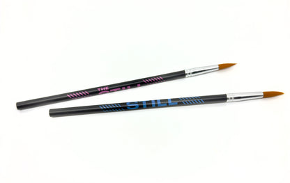 Two "The Still" branded pencils with paint brushes on one end
