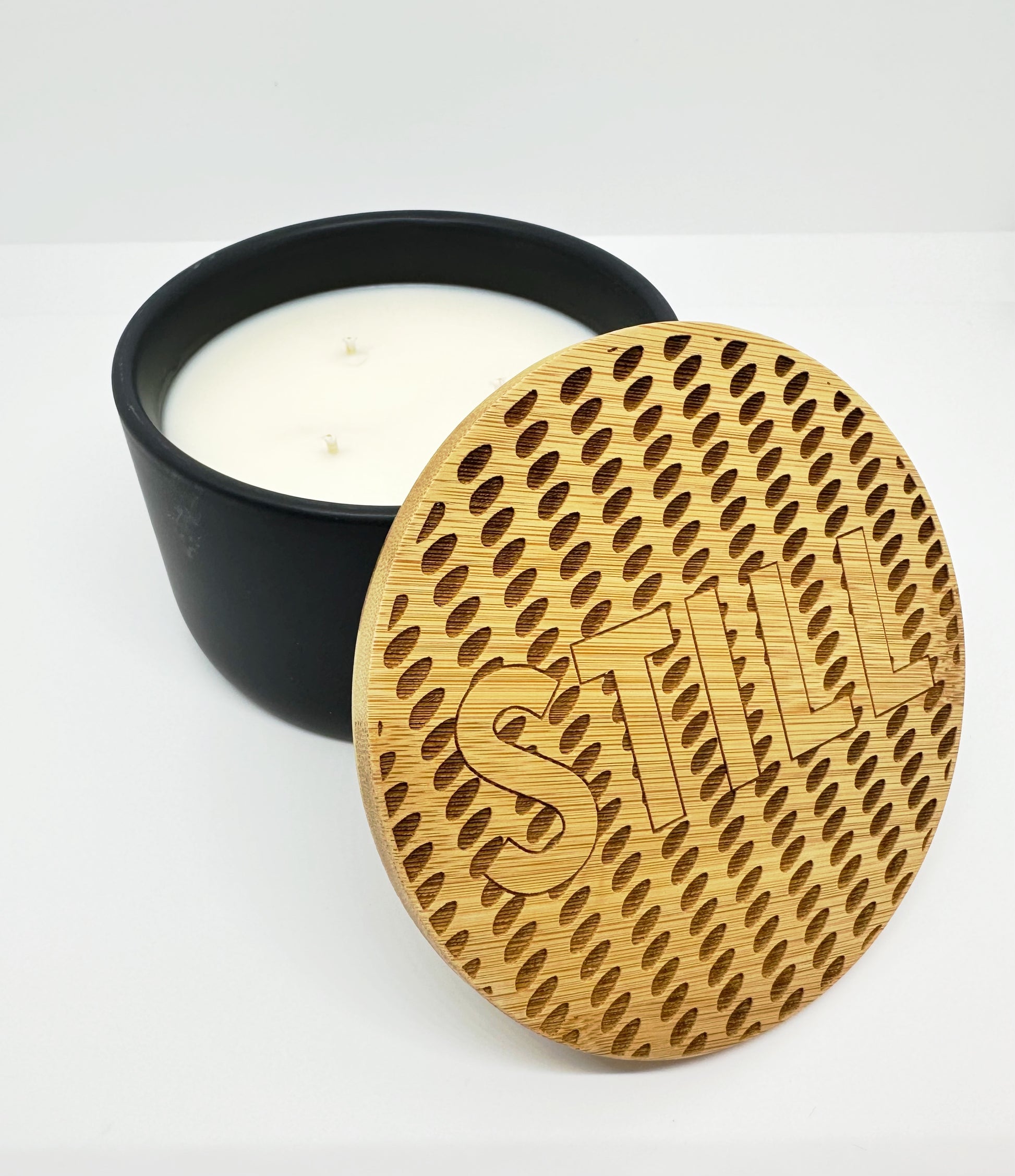 Large candle in black ceramic and topped with a Museum ceiling inspired laser-engraved bamboo lid. 