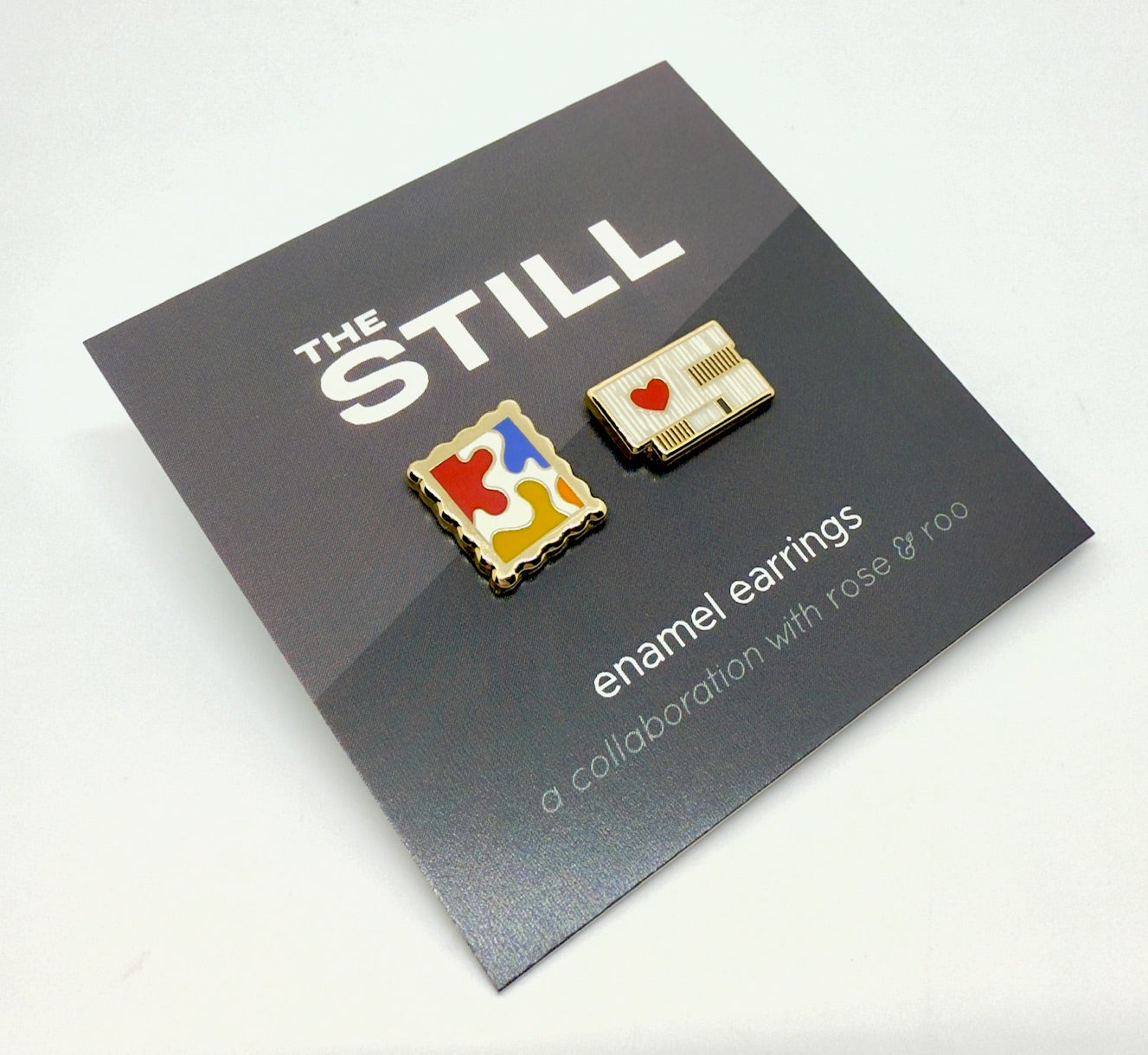 Enamel earrings of the Clyfford Still Museum building and a painting