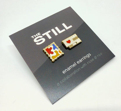 Enamel earrings of the Clyfford Still Museum building and a painting