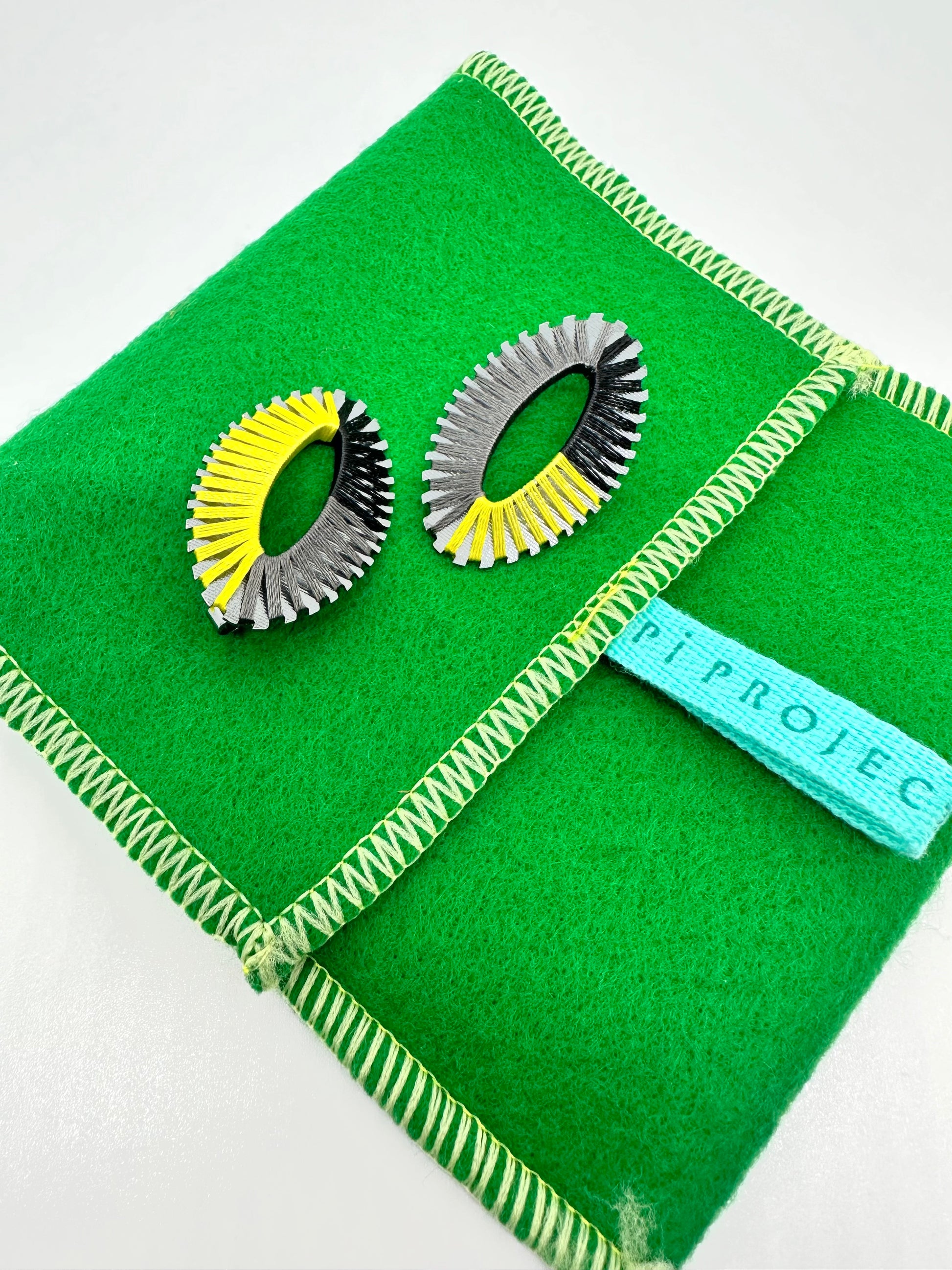 Image of Oval String Earrings/ Yellow, Black and Gray with case.