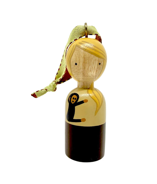 Wooden peg doll with yellow hair holding a chimpanzee on a white background.