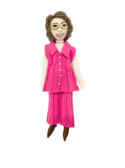 Textile doll wearing a pink outfit on a white background
