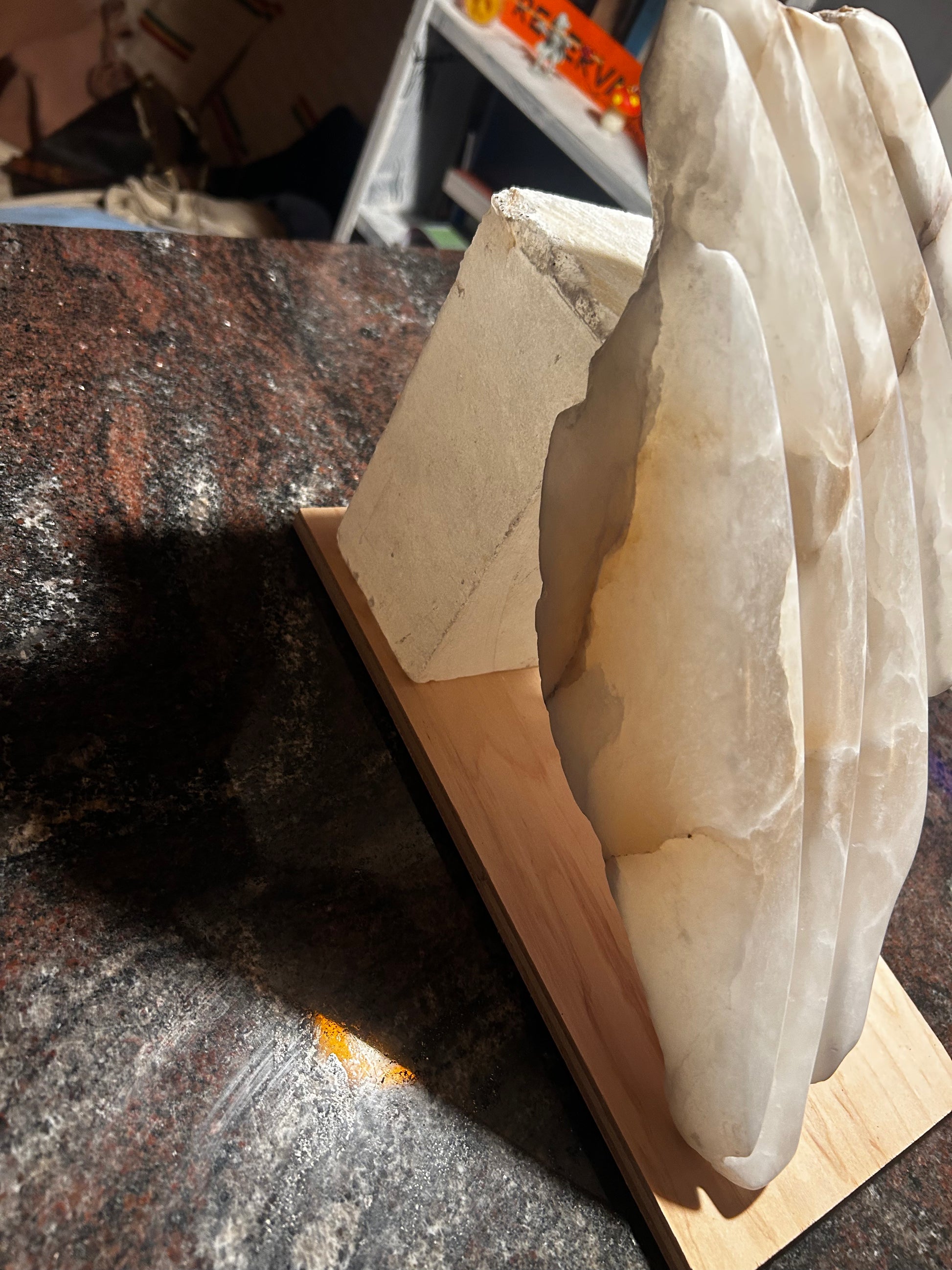 Alabaster slab on a wooden stand with a blurred background.
