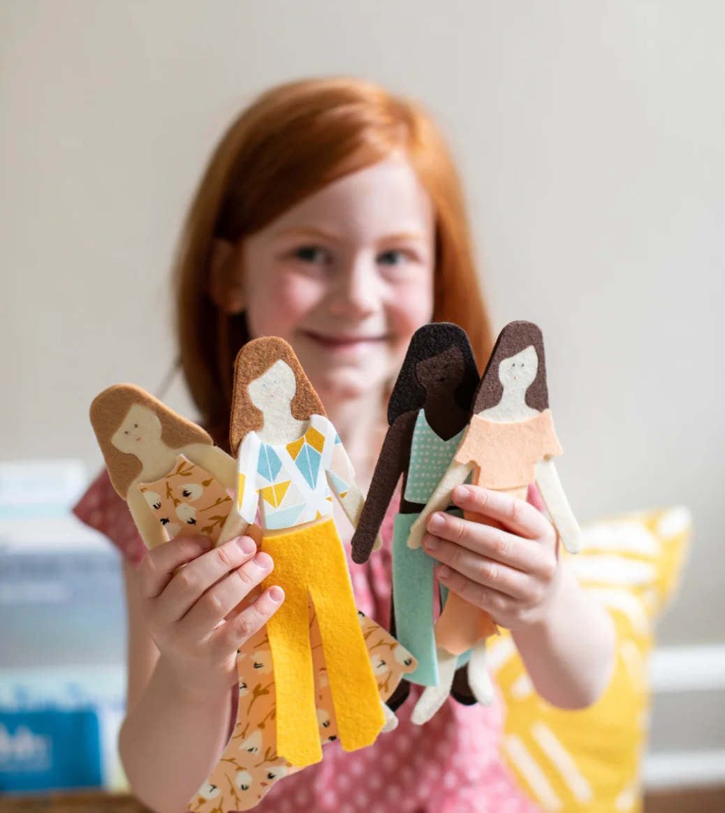 Girl holding 4 variants of the ‘Long Haired Felt Dolls’