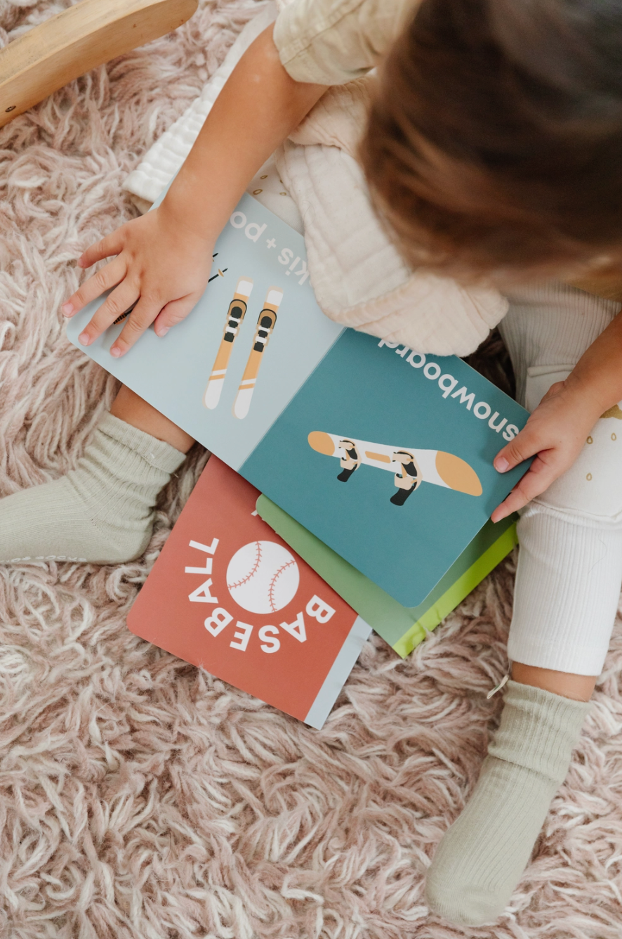 Top view of a toddler holding a square picture book 