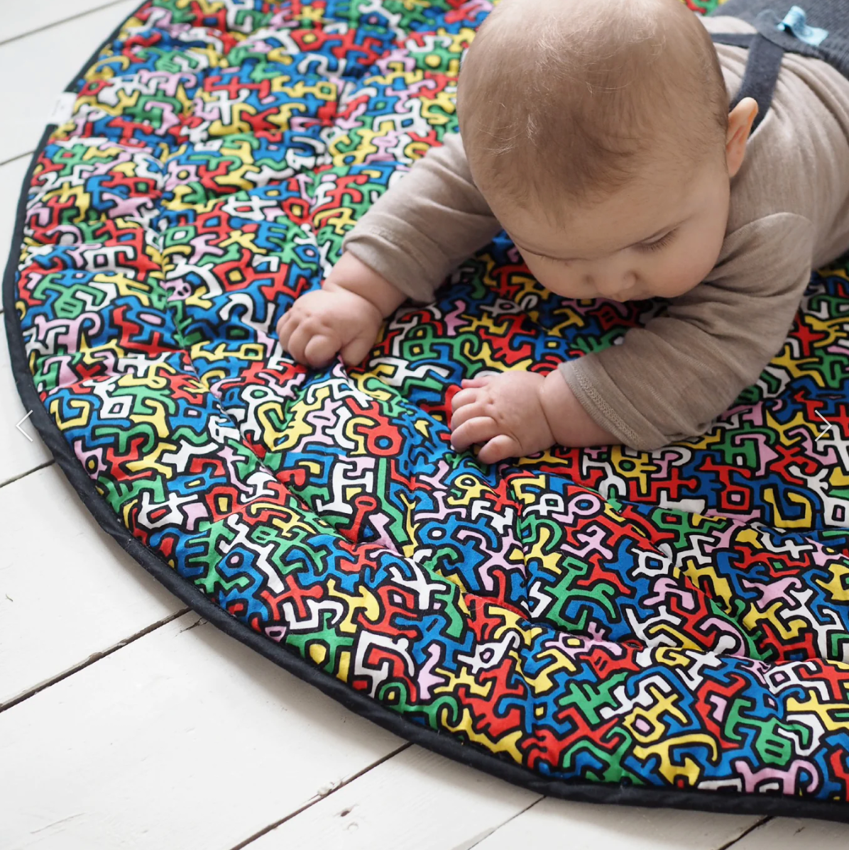 Photo of baby on a Keith Haring playmat.