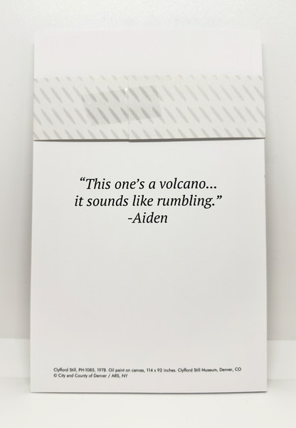 White notebook with black quote text on the back saying "This one's a volcano... it sounds like rumbling."