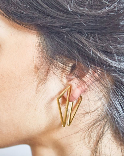 Gold geometric earring being worn