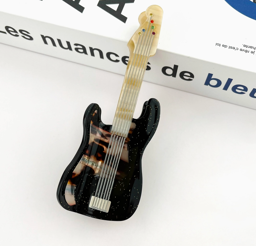 Guitar-shaped hair clip on a magazine page