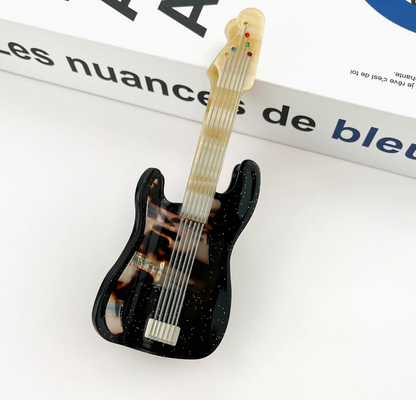 Guitar-shaped hair clip on a magazine page