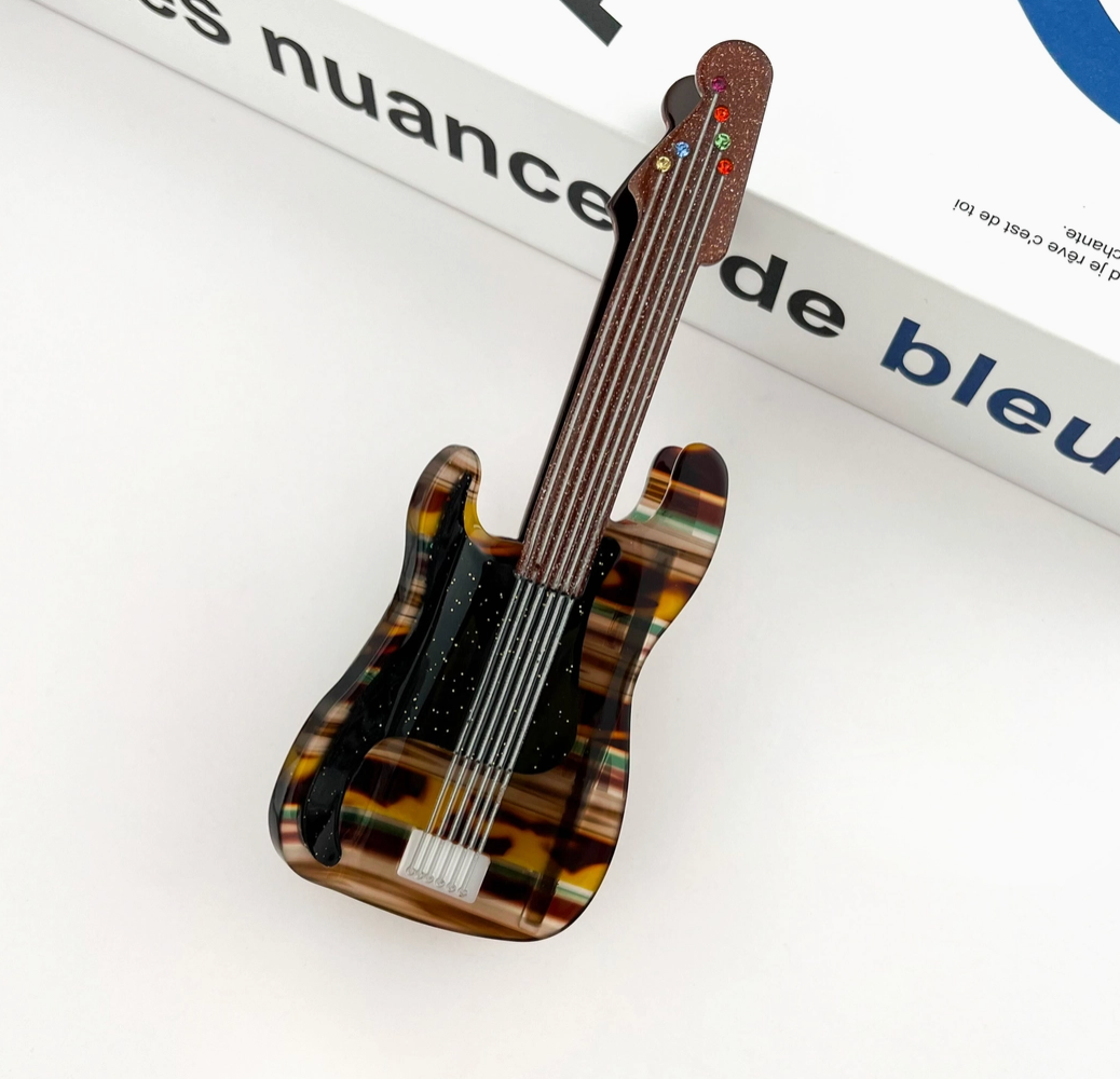 Guitar-shaped hair clip on a magazine page