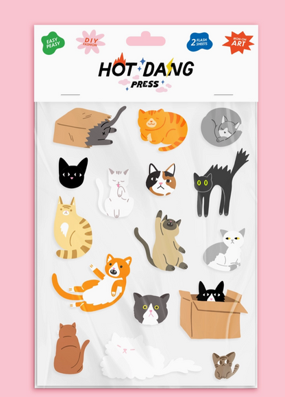 Sheet of cat-themed ion-on decals by Hot Dang Press on a pink background