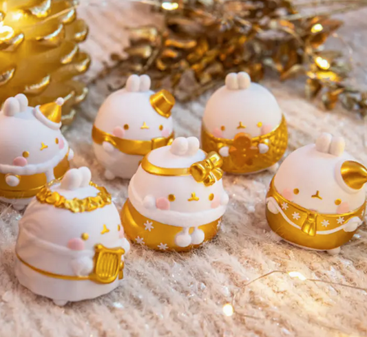 Set of small decorative figurines with gold accents on a textured surface.