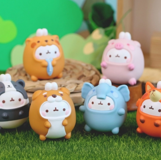 Set of cute animal figurines on a grassy surface with a blurred green background