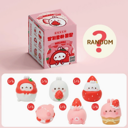 Box of random figurines with character designs on a pink background