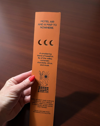 Orange product packaging held by a hand on a wooden surface