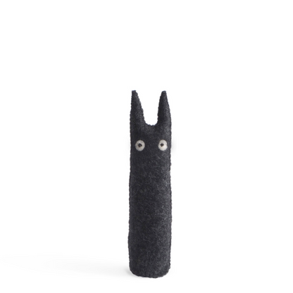 Dark gray plush figure with googly eyes on a white background
