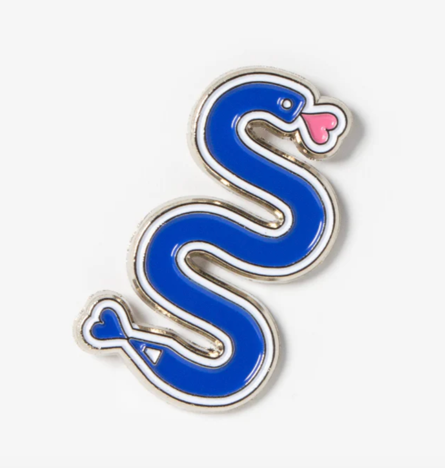 Blue snake-shaped enamel pin with a pink heart on a white background