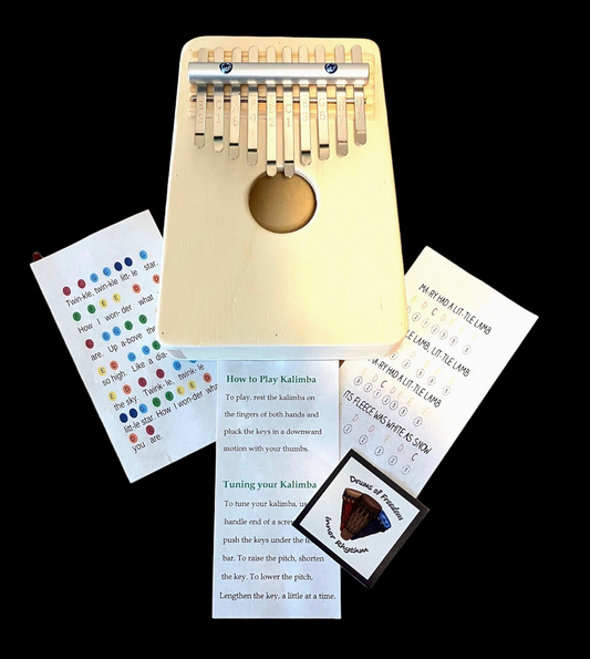 Wooden kalimba with instructional cards and a small pouch on a black background