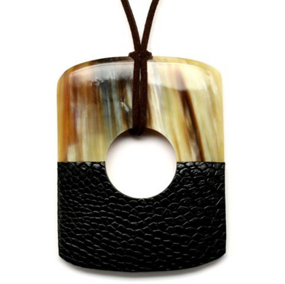 Necklace with a black leather pendant and a large central hole, featuring a natural horn-like material.
