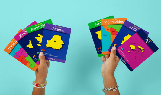 Hands holding colorful cards with map illustrations against a light blue background
