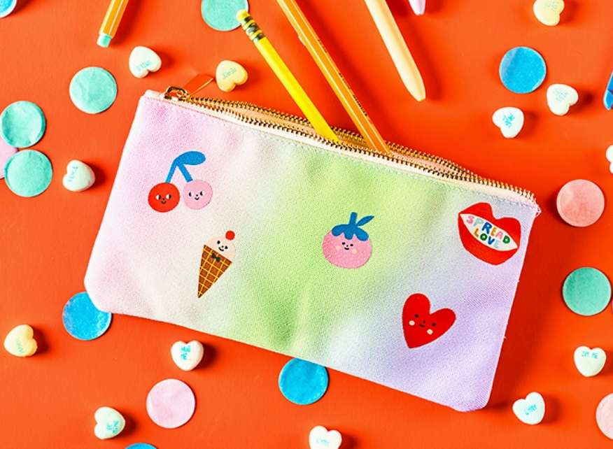 Colorful pencil case with cartoon designs on a red background with confetti