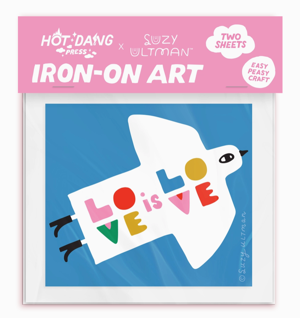 Iron-on art package with a dove holding 'LOVE' on a blue background, featuring Hot Dang Press and Suzy Ultman branding.
