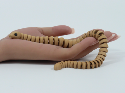 Hand holding a brown fidget snake toy with a white background.