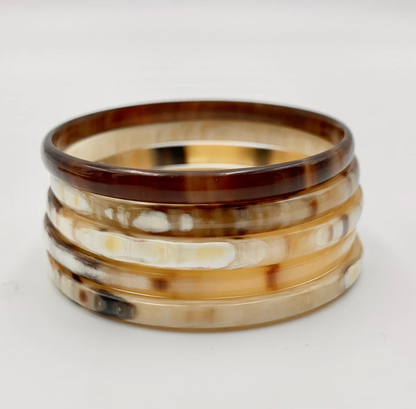 Brown and beige horn bangles on a white background.