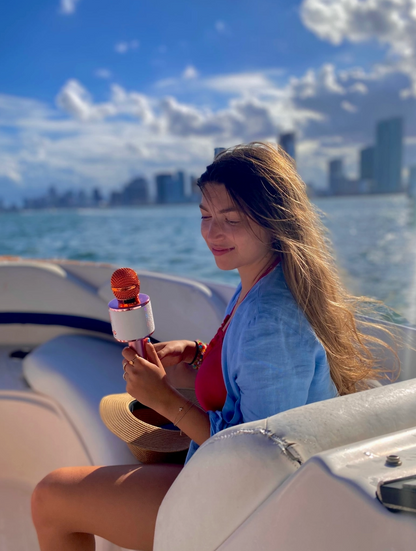 Woman on a boat holding a microphone with a city skyline in the background