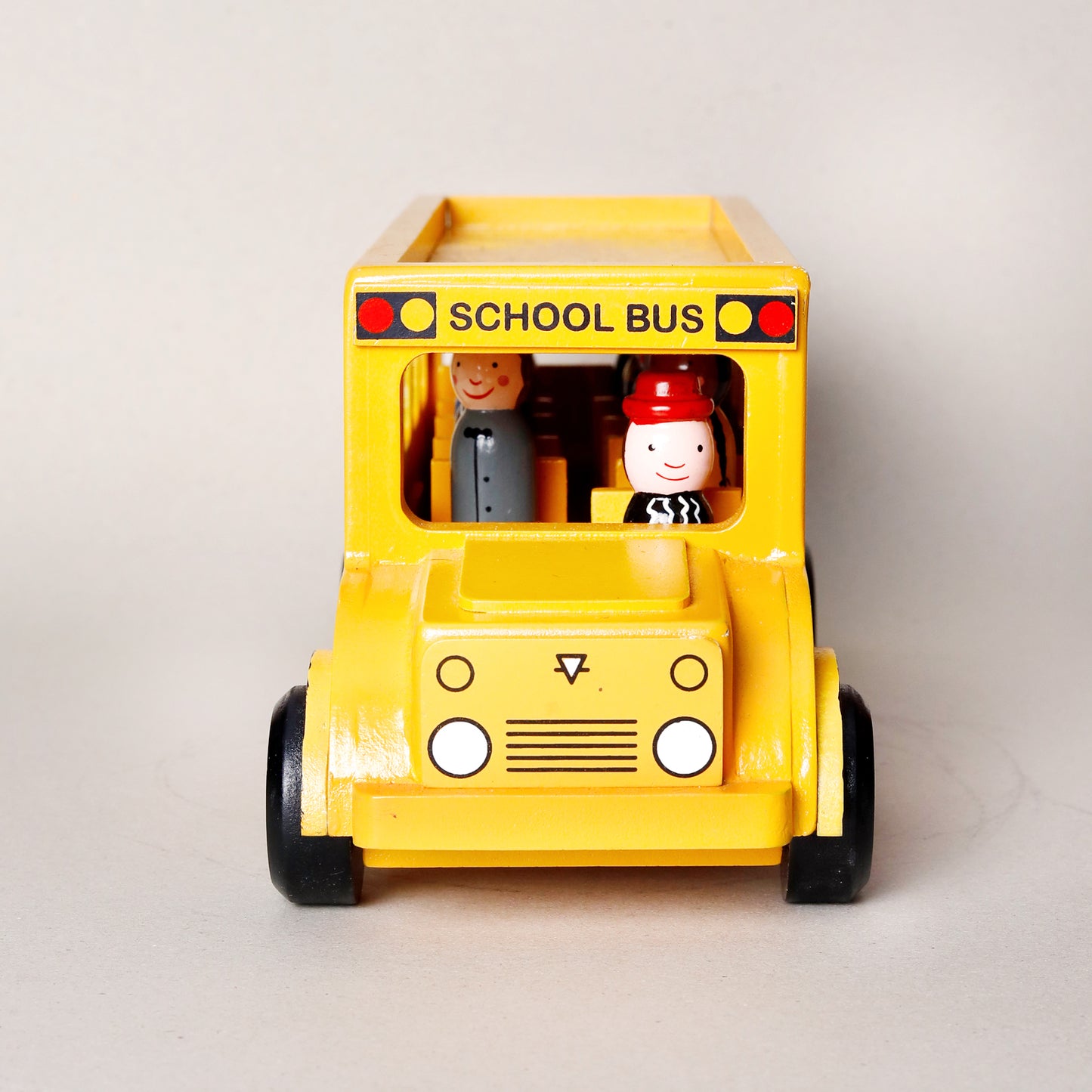 Toy school bus with two figures on a light gray background