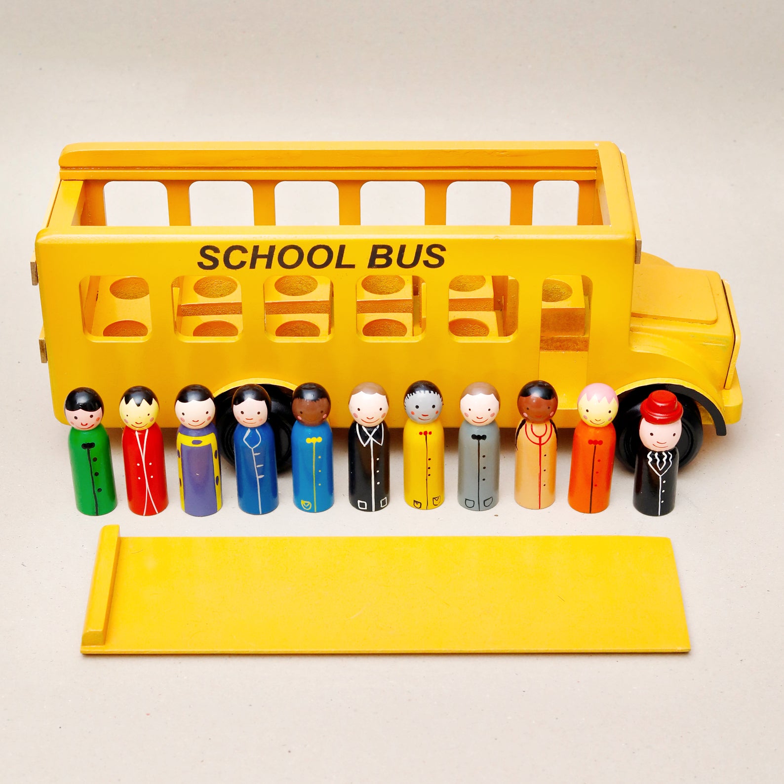 Toy school bus with diverse toy figures on a white background