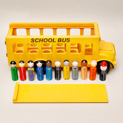 Toy school bus with diverse toy figures on a white background