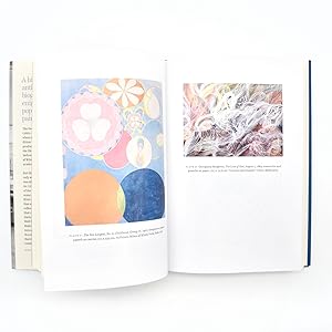 An open book showing two illustrated pages with pastel and abstract artwork, photographed against a plain white background.