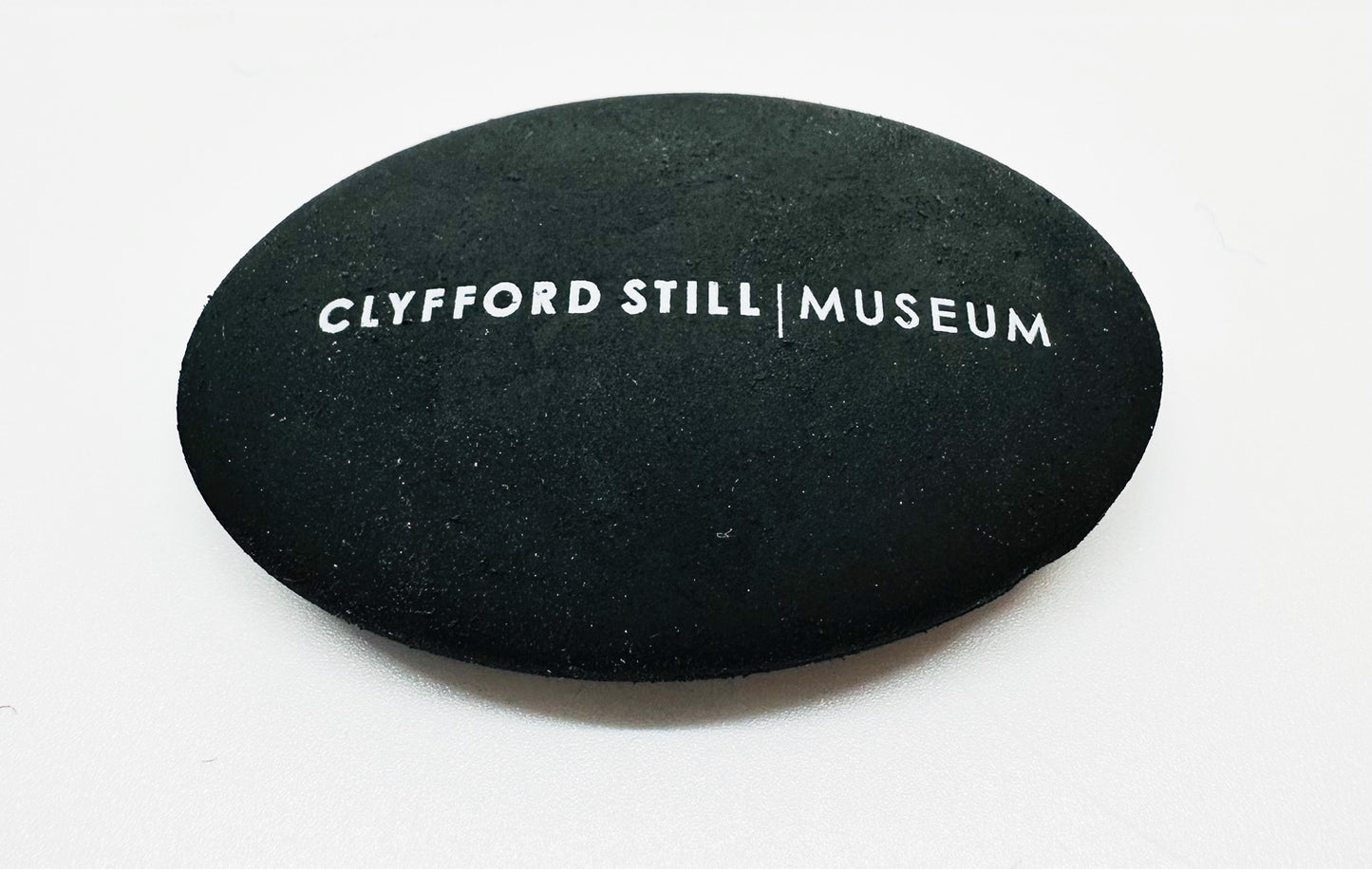 Black Pebble Eraser with Clyfford Still Museum logo.